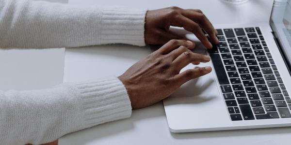 person working on laptop with notebooks