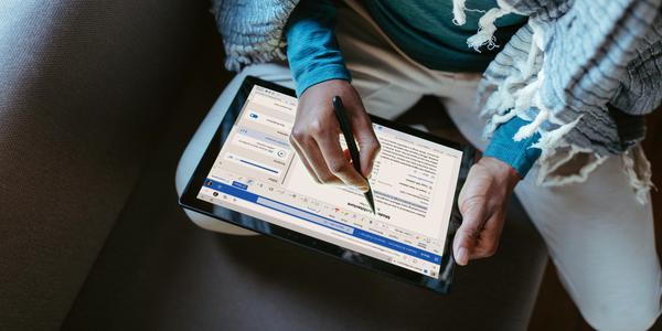 overhead view of someone taking notes on a tablet with a stylus