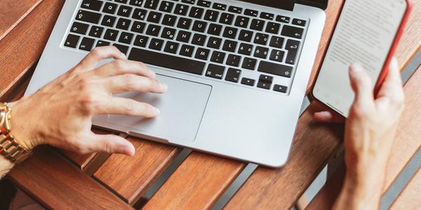 overhead view of someone using Macbook Pro and iPhone